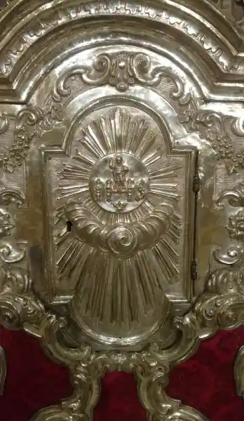 IHS with baby Jesus on top and in the middle of sun symbol